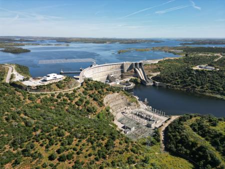 Bird view of Alqueva reservoir on a sunny day with two levels of water surrounded in greenery